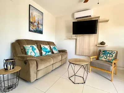 a living room with a couch and a chair at Parakeet Paradise 2nd floor Condo with Rooftop in Coco
