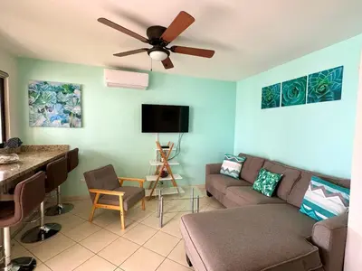 a living room with a couch and a ceiling fan at Ocean Breeze Condo in Coco