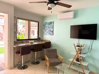 a living room with a desk and a flat screen tv at Ocean Breeze Condo in Coco