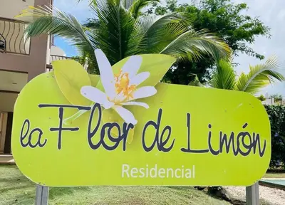 a sign for a hotel in front of a palm tree at Ocean Breeze Condo in Coco
