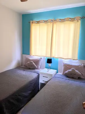 two beds in a bedroom with blue walls and a window at High Tide 2 bed1 bath condo Terrace in Coco