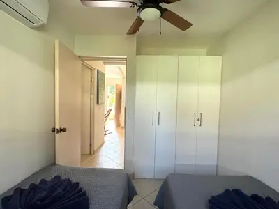 a bedroom with a ceiling fan and white cabinets at High Tide 2 bed1 bath condo Terrace in Coco