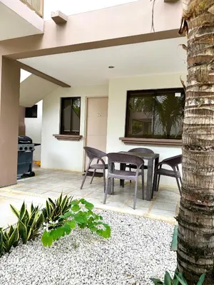 a patio with a table and chairs and a palm tree at EndlessSummer Beach Escape in Coco