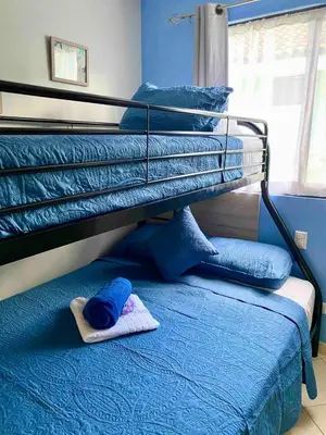 a bunk bed with a hat on the bottom bunk at Sun and Waves Getaway in Coco