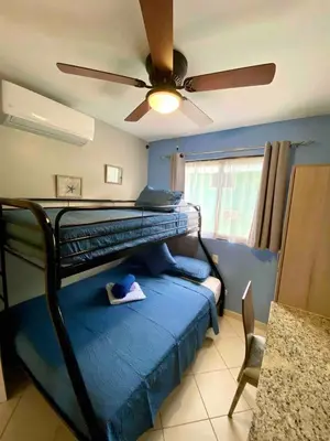 a bedroom with a bunk bed with a ceiling fan at Sun and Waves Getaway in Coco