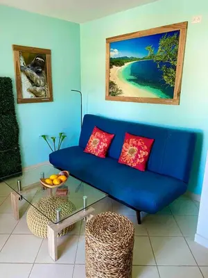 a blue couch with red pillows in a living room at Discounted - PuraVida Escape and rooftop terrace in Coco