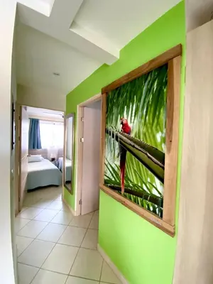 a red bird sitting on a window in a room at Discounted - PuraVida Escape and rooftop terrace in Coco