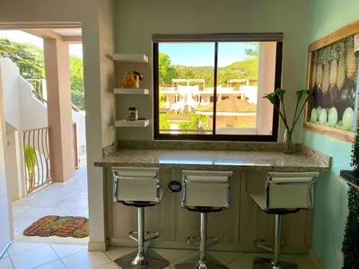a kitchen with two bar stools and a window at Discounted - PuraVida Escape and rooftop terrace in Coco