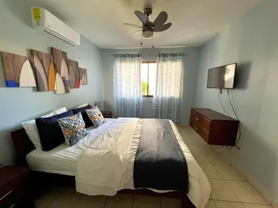 a bedroom with a bed and a ceiling fan at Sea Bottom Ground Condo in Coco