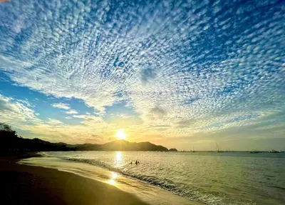 a sunset on the beach with a cloudy sky at Sea Bottom Ground Condo in Coco