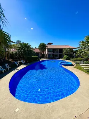 a large blue swimming pool in front of a house at Coral Reef Condo in Coco