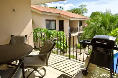 a balcony with a grill and a table and chairs at Coral Reef Condo in Coco