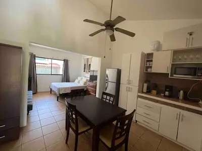 a kitchen and dining room with a table and a ceiling fan at Cabaña en el Sol Cabin in the Sun in Ocotal