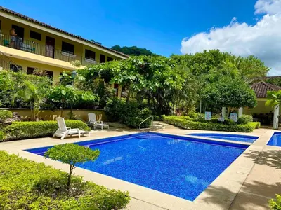 a swimming pool in front of a building at Cabaña en el Sol Cabin in the Sun in Ocotal