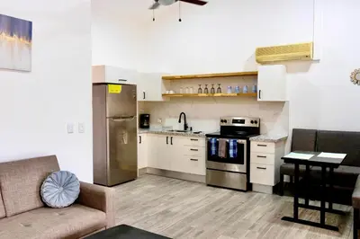 a kitchen with a couch and a stove top oven at Discounted - Hermosa Paradise Mins from beach in Playa Hermosa