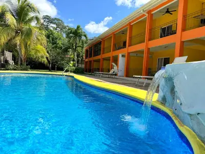 a swimming pool with a waterfall in front of a building at Discounted - Hermosa Paradise Mins from beach in Playa Hermosa