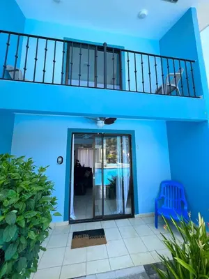 a blue house with a staircase and a door at Charming Condo Orchidea in Coco