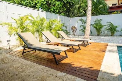 a group of lounge chairs sitting on a wooden deck at Tropical brand new 4 BR gem in Potrero near beach - Casa Marzo in Potrero