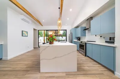 a kitchen with blue cabinets and a white counter top at Tropical brand new 4 BR gem in Potrero near beach - Casa Marzo in Potrero