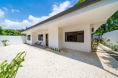a white house with a black roof at Tropical brand new 4 BR gem in Potrero near beach - Casa Marzo in Potrero