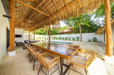 an outdoor dining room with a wooden table and chairs at Tropical brand new 4 BR gem in Potrero near beach - Casa Marzo in Potrero