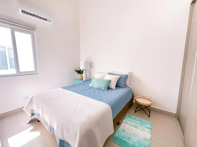 a bedroom with a bed with blue and white sheets at Pura Vida Apartment with nice pool walking distance to the heart of Jaco in Jacó