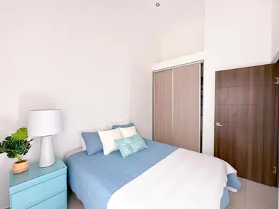 a bedroom with a bed with a cabinet and a lamp at Pura Vida Apartment with nice pool walking distance to the heart of Jaco in Jacó