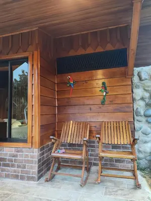 two benches sitting on the side of a cabin at Pitangus Lodge in Chachagua