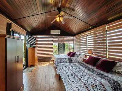 a bedroom with two beds and a ceiling fan at Pitangus Lodge in Chachagua