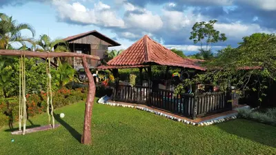 a house with a gazebo in a yard at Pitangus Lodge in Chachagua