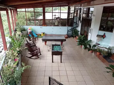 an indoor patio with a table and chairs and plants at Natural Pacific Suites, Manuel Antonio-Quepos-Hotel in Manuel Antonio