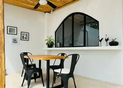 a table and chairs in a patio with a window at Las Guapas Villas Tamarindo in Tamarindo