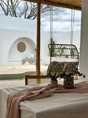 a bed in a room with a chair and a window at Las Guapas Villas Tamarindo in Tamarindo