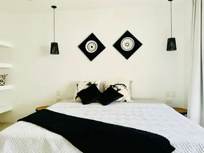 a bedroom with a bed with black and white pillows at Las Guapas Villas Tamarindo in Tamarindo