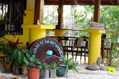 a building with a sign in a yard with plants at Casa de la Naturaleza in Cóbano