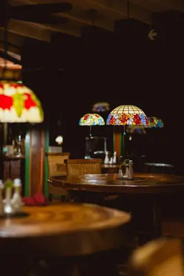 a restaurant with tables and stained glass lamps at Trogon Lodge in San Gerardo de Dota