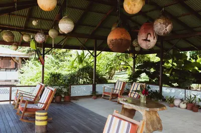 a group of chairs and a table on a patio at Mawamba Lodge in Tortuguero