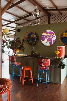 a restaurant with colorful stools and signs on the wall at Mawamba Lodge in Tortuguero