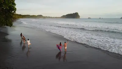 a group of people walking on the beach with a kite at Buena Vista Plus in Quepos
