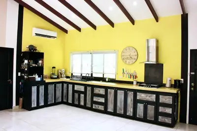 a kitchen with yellow walls and a clock on the wall at Casita Mar Y Posa in Potrero
