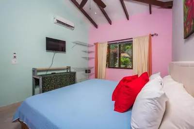 a bedroom with a large bed with red pillows at Casita Mar Y Posa in Potrero