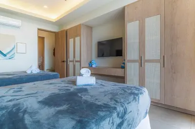 a bedroom with two beds and a flat screen tv at Casa Frenchie with Private Guesthouse - by Pura Villas in Dominicalito