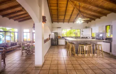 a kitchen and dining room with a table and chairs at Casi el Cielo - by Pura Villas in Uvita