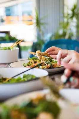 a person eating a plate of food on a table at Casi el Cielo - by Pura Villas in Uvita