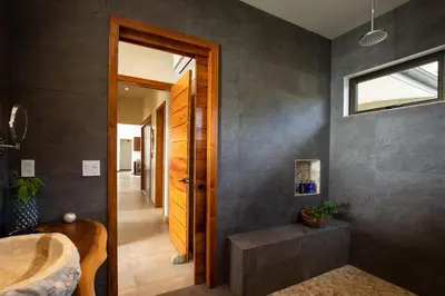a bathroom with a sink and a wooden door at Casa Ola Vista - by Pura Villas in Dominicalito