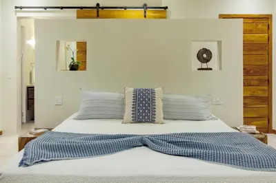 a bed with blue and white sheets and pillows at Casa Ola Vista - by Pura Villas in Dominicalito