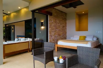 a bedroom with a bed and a table and chairs at Casa Ola Vista - by Pura Villas in Dominicalito