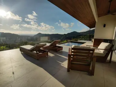 a patio with chairs and a pool with a view at Casa Grande del Mar - by Pura Villas in Punta Mala