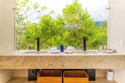 a bathroom with two sinks and a large window at Casa Grande del Mar - by Pura Villas in Punta Mala