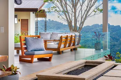 a patio with two chairs and a bench on a porch at Casa Grande del Mar - by Pura Villas in Punta Mala